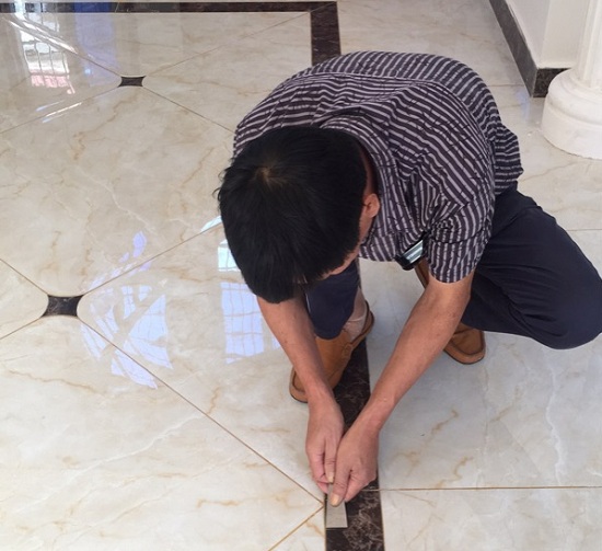 王先生正在給客廳瓷磚美縫施工